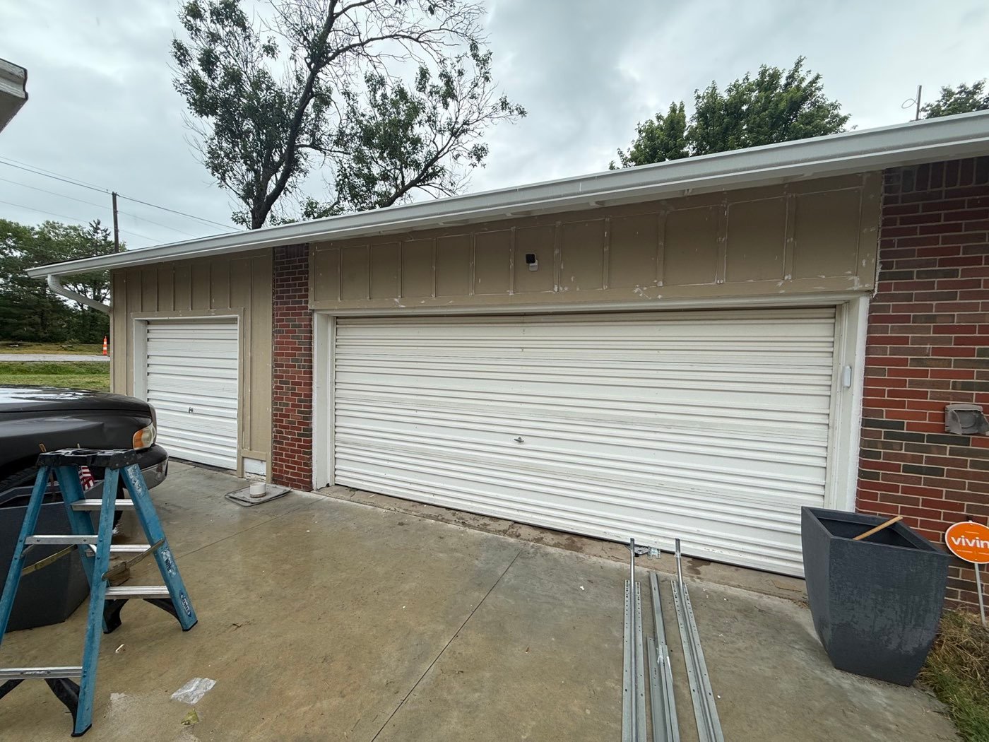 Before: old dented white garage doors