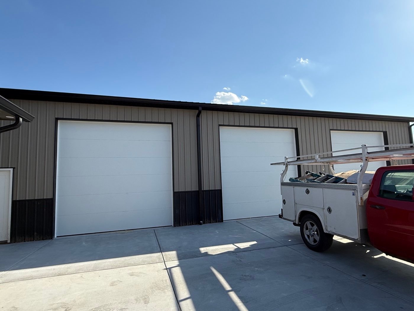 Large white overhead doors on a commercial steel building