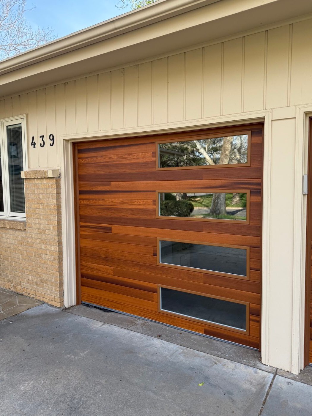 Modern wood-look garage door with glass windows